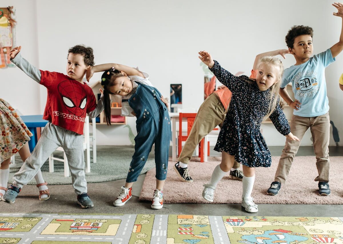 Group of diverse preschool children engaging in fun exercises indoors.